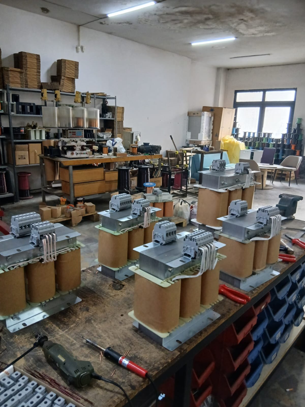 Atölyede sıralanmış üç fazlı kuru tip trafo gövdeleri ve bağlantı terminalleri