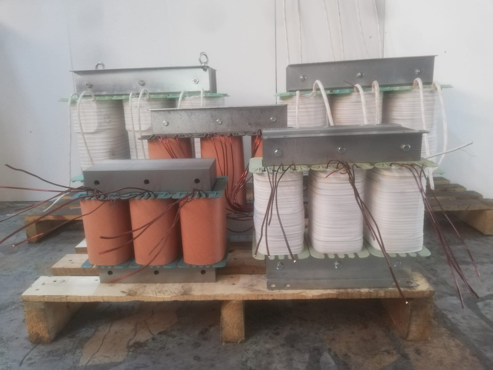 Yan yana dizilmiş trafo sargı gövdeleri ve bakır bağlantı kabloları