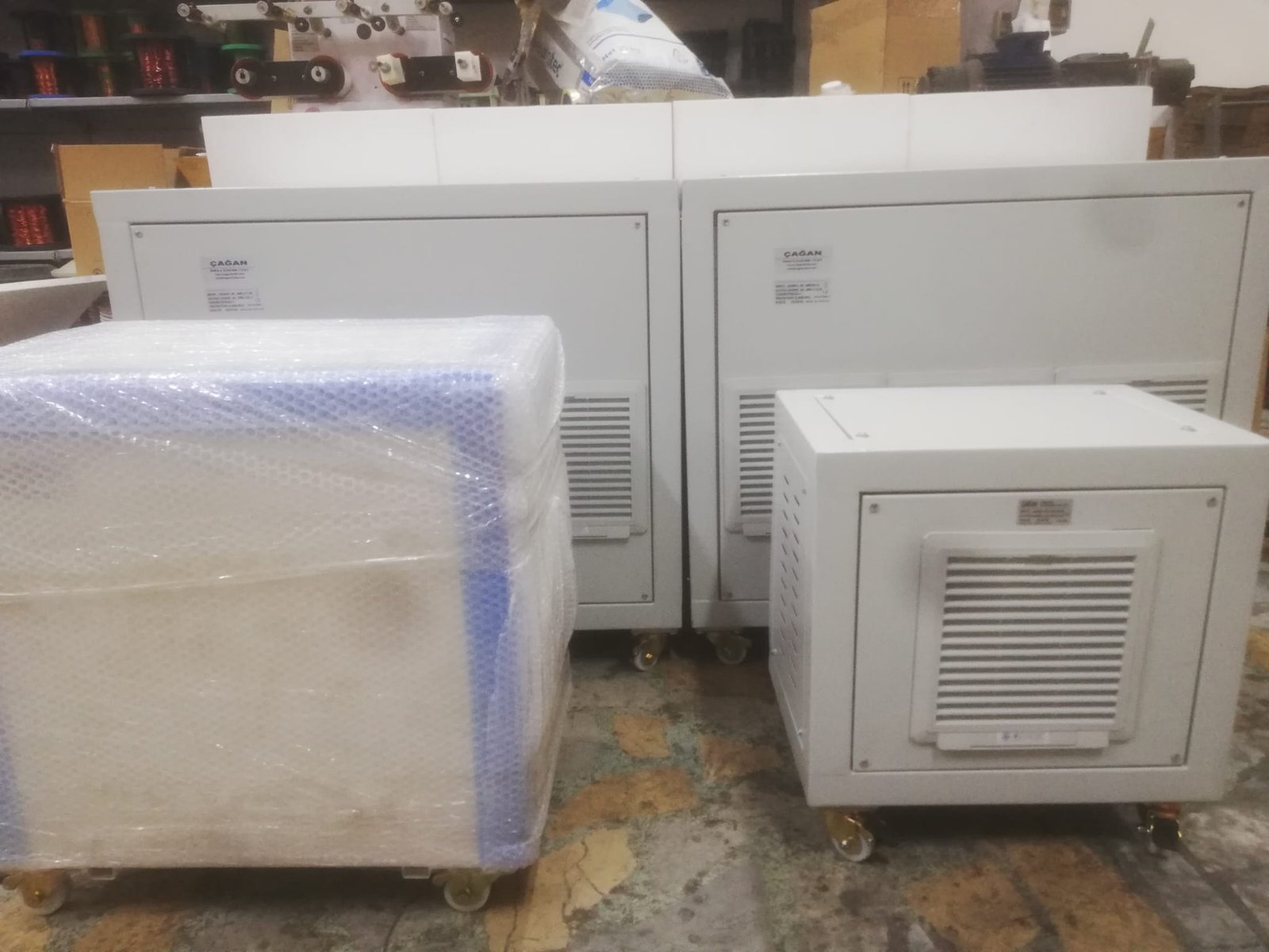Paketlenmiş ve tekerlekli metal kabinetler, sevkiyat öncesi atölye görünümü