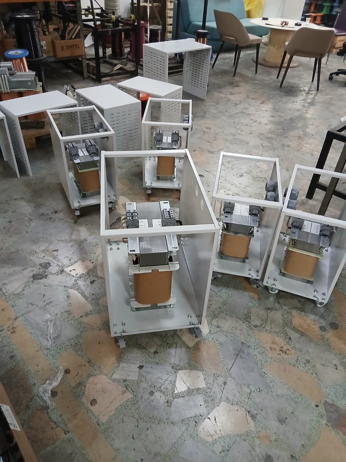 Kabinet gövdeleri içinde monte edilmiş trafo üniteleri, atölye zemininde sıralı